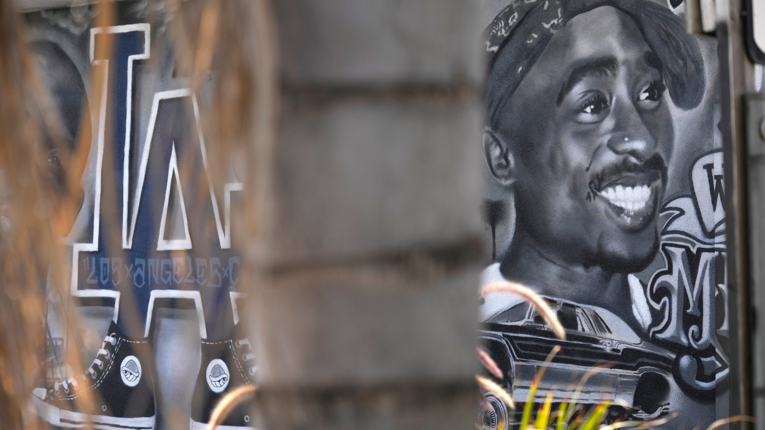 A portion of a mural by artist sloe_motions depicting Tupac Shakur is seen on the side of Speedy Auto Tint on Friday, Sept. 29, 2023, in Bellflower, Calif. (AP Photo/Chris Pizzello)