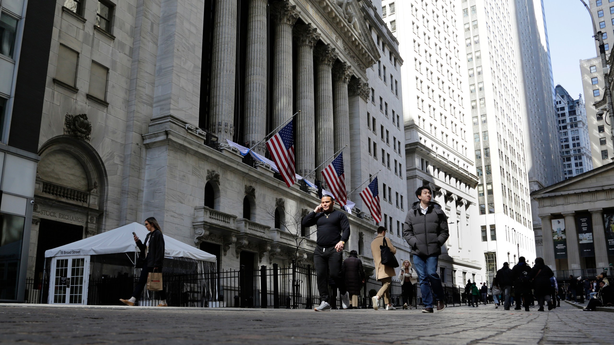 FILE - People pass the front of the New York Stock Exchange in New York, March 21, 2023. Wall Street is retreating a bit more as a five-week rally loses momentum. (AP Photo/Peter Morgan, File)